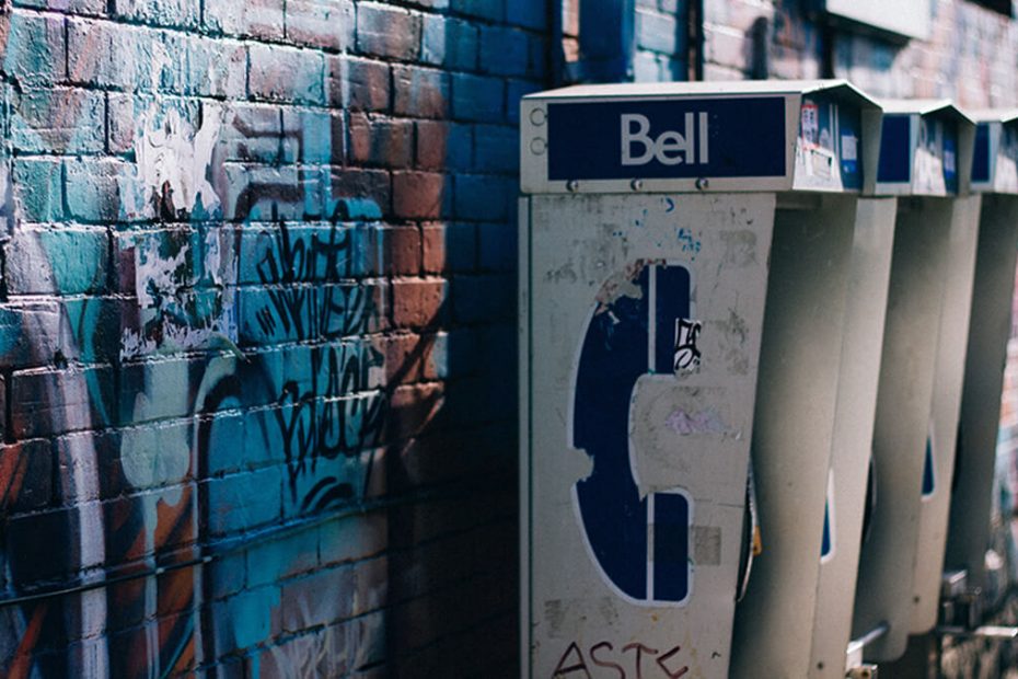 city pay phones on wall with graffitti for post about sales calls