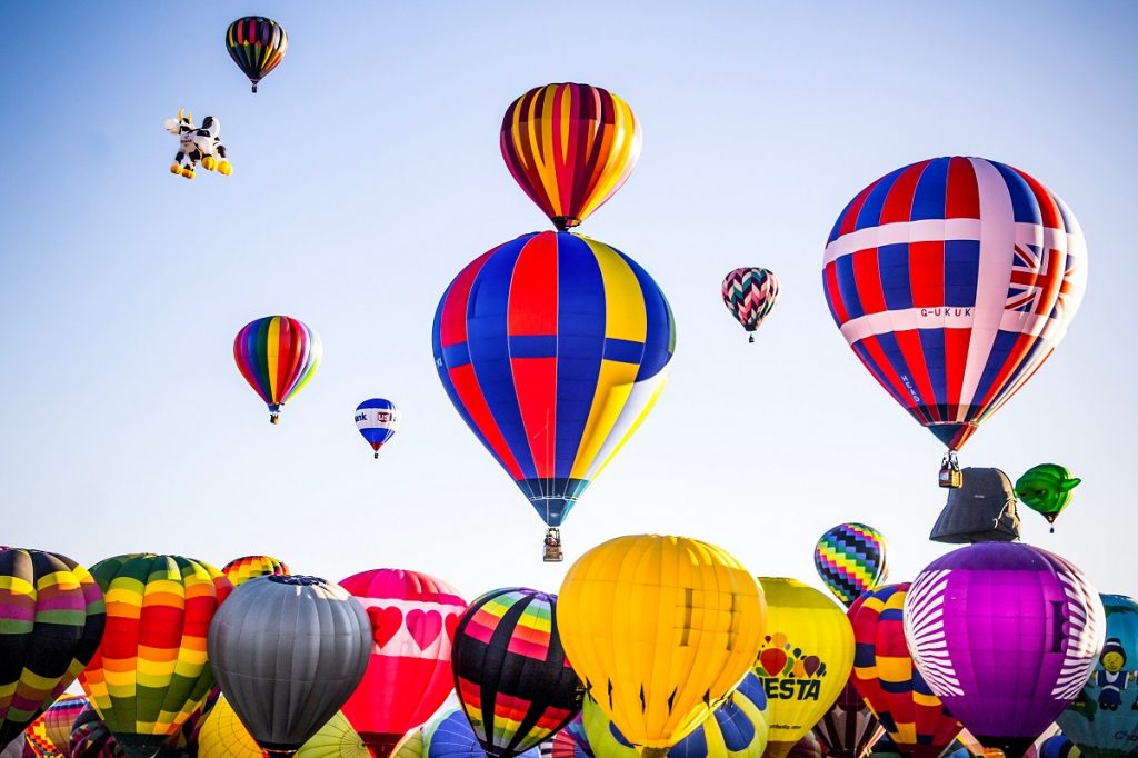 A collection of hot air balloons taking off, meant as a representing services business that takes flight